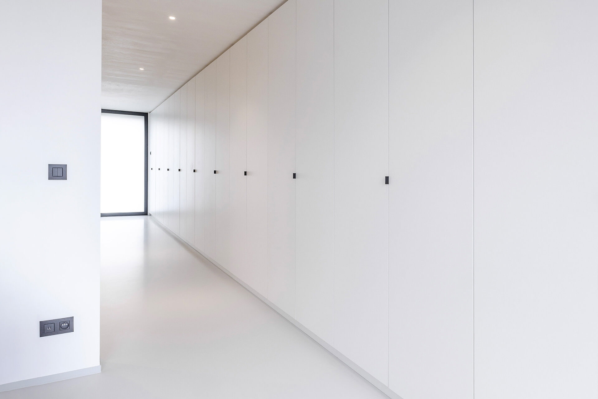 Ingebouwde opbergkasten over de hele wand, van maatkastenonline