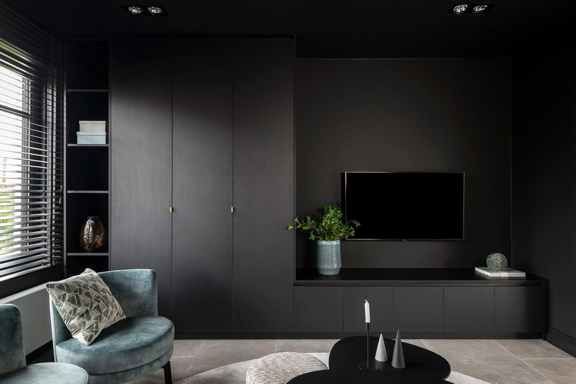 Een wandcombinatie van hoge kasten en tv-meubel in Elegant Black tegen een zwarte muur