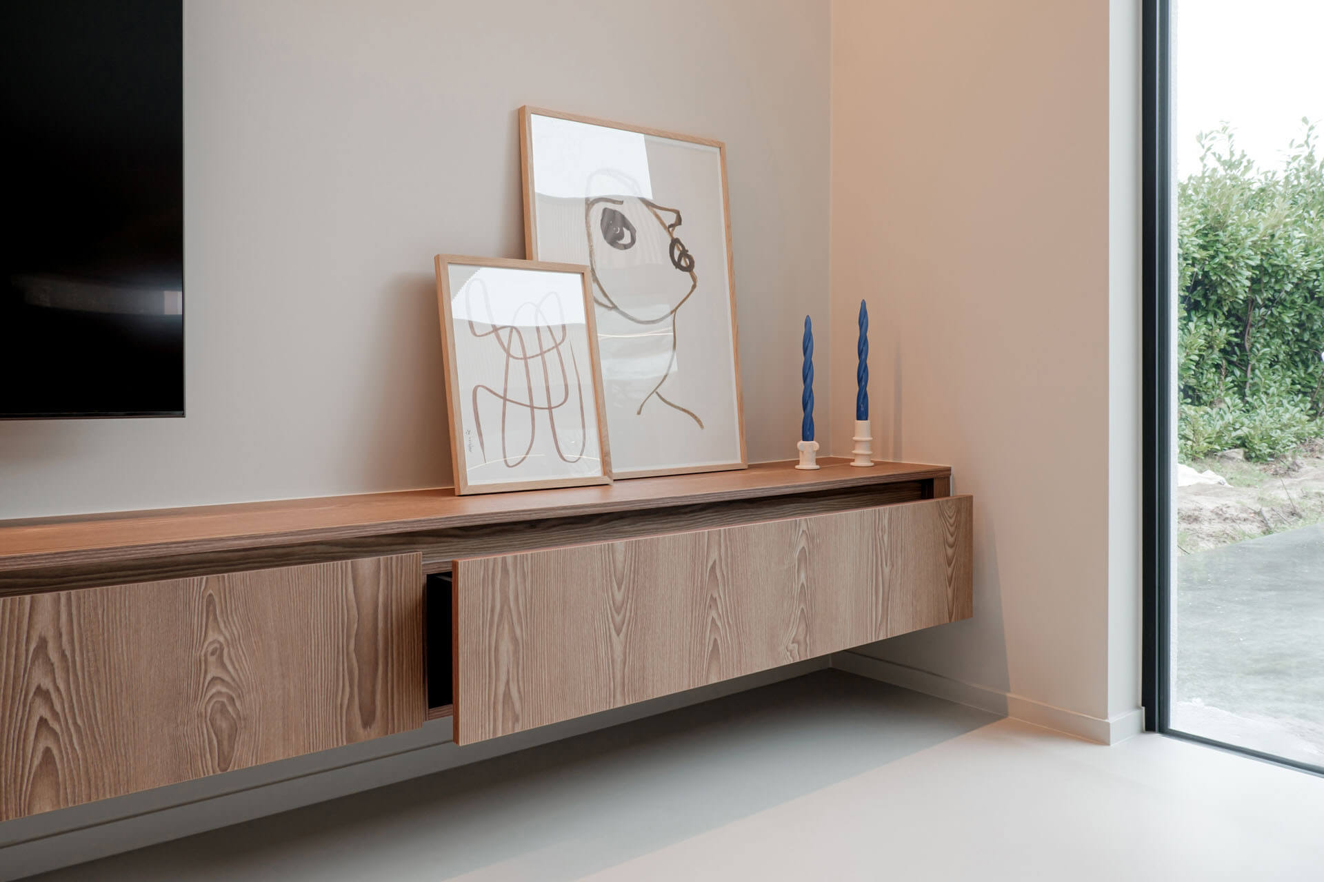Een lange tv-meubel in Sunlit Brown met twee fotokaders en kaarsen