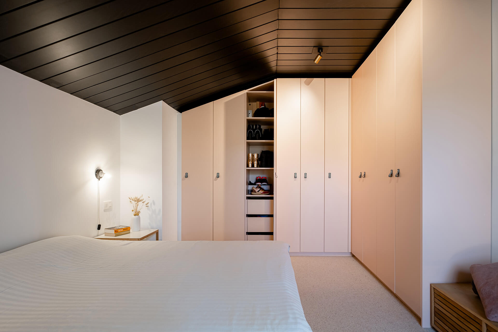 Roze kleerkast op maat onder een schuin dak in de slaapkamer